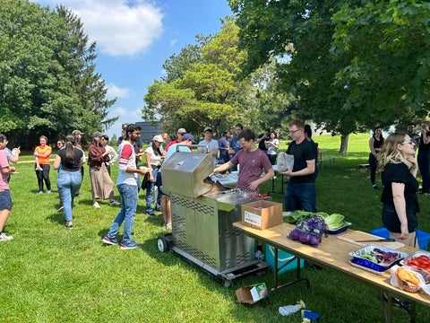 Chemistry graduate students serving barbeque meals.