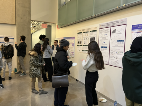 people standing in front of their research posters