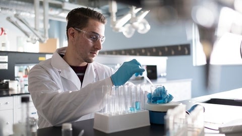 Student in the lab preparing test tubes.