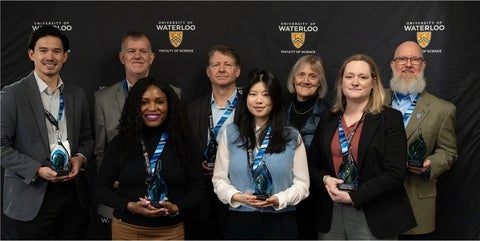 Eight 2025 Alumni Award recipients holding their awards.