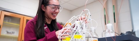 An undergraduate student setting up an experiment in the lab.