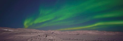 Scenic view of aurora borealis against sky at night. Iqaluit, Nunavut, Canada. Getty Images.