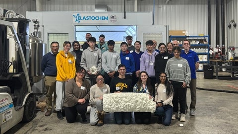 Group of students at Elastochem company, holding a piece of spray foam insulation