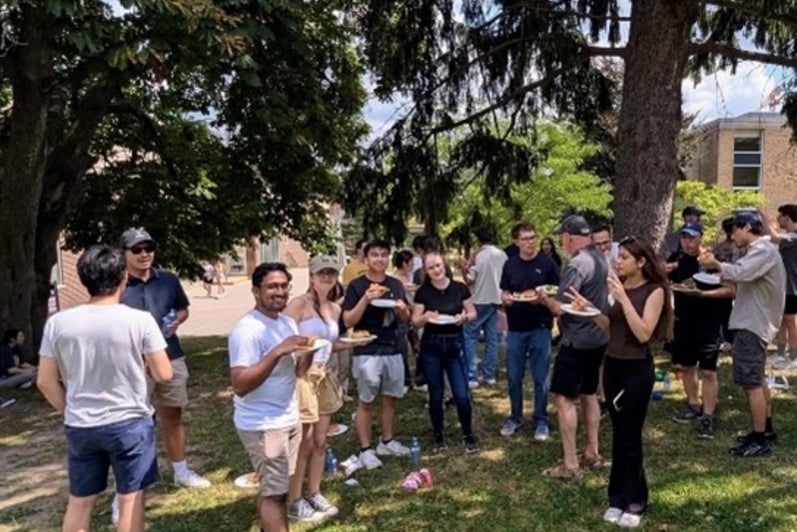 Students outside eating under a tree.