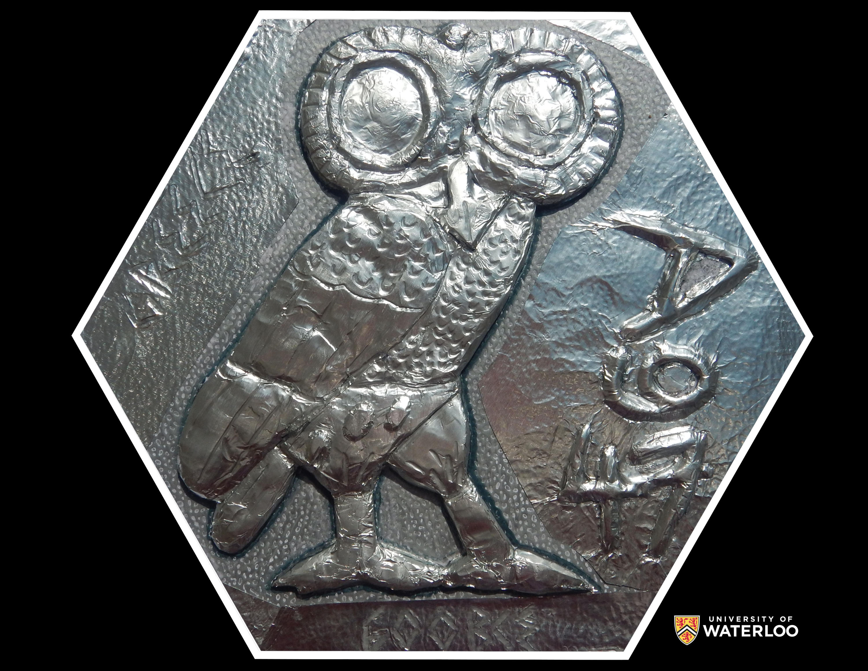 Aluminum foil relief over clay. Large owl centre. Chemical symbol “Ag” and atomic number “47” on the right. On the left “Greece”; bottom is “600 BCE”.