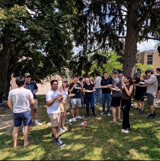 Students outside eating under a tree.