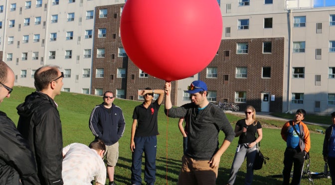 Grant holding a weather balloon during a lab session.