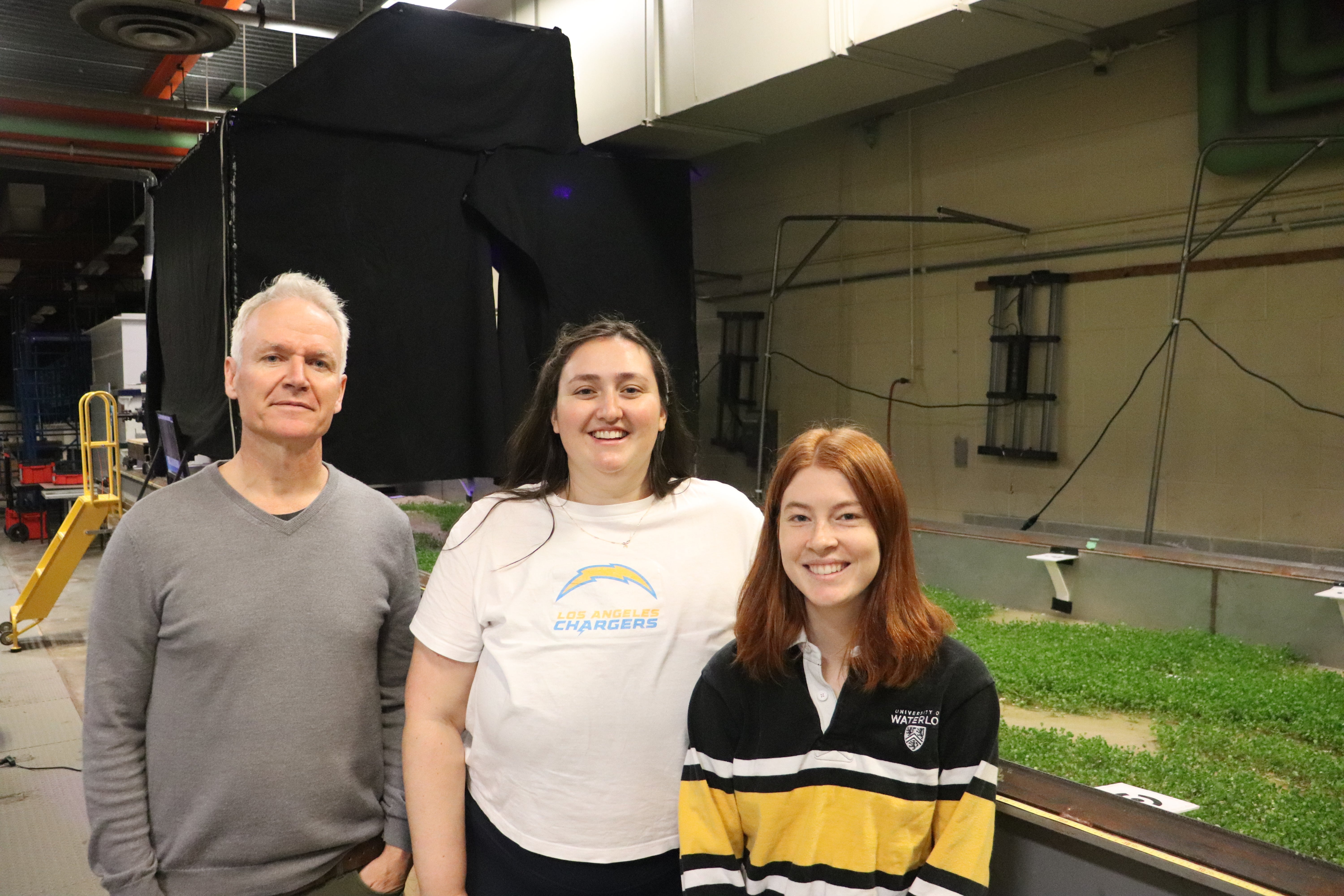 man and 2 students standing in front of flume