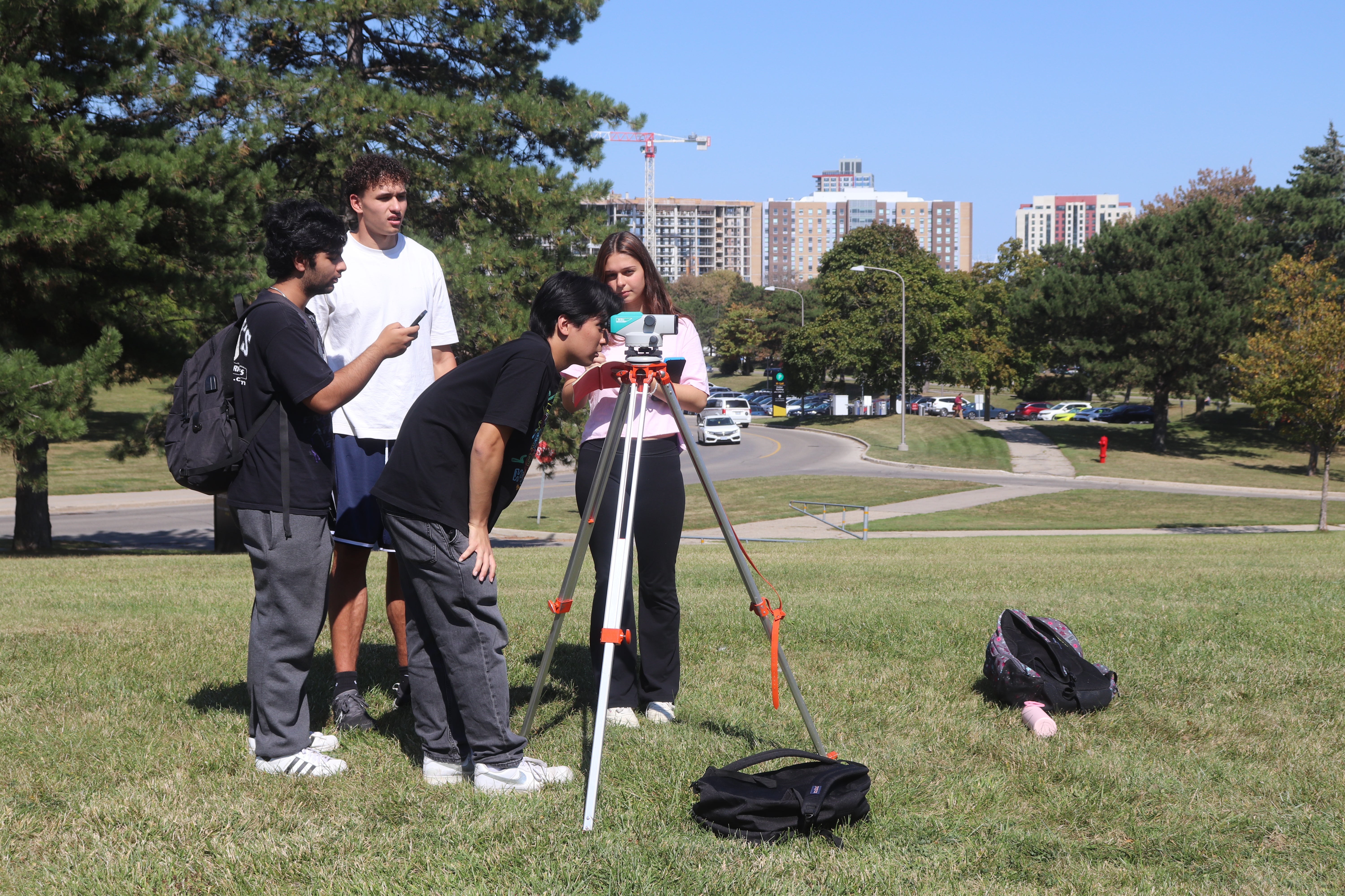 4 students standing around a field survey tool