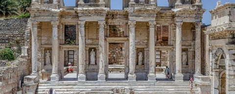 Large entrance to ancient building with people exploring