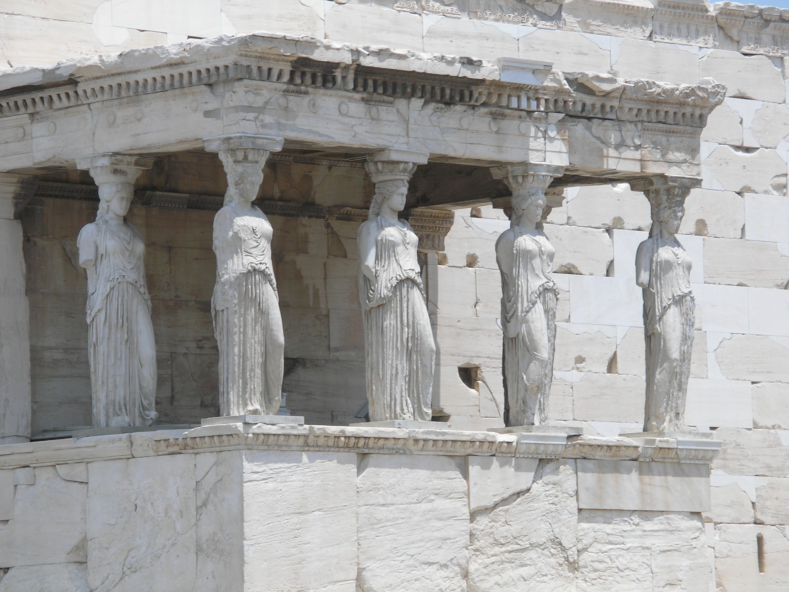 Close up of the ruins of a temple. The columns are sculptures of women in long drapery, suggesting priestesses or maidens who served in the temple