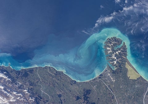 Satellite view of turquoise ocean currents and coastal landscape