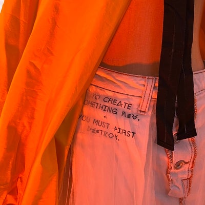 Writing on skirt reads “To create something new, you must first destroy.”