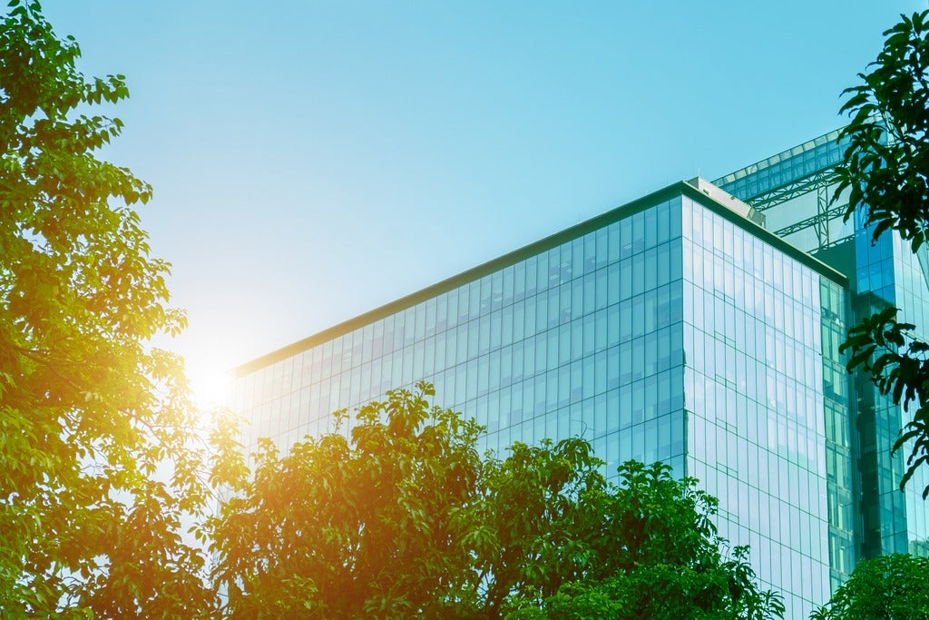 Tall buildings surrounded by trees.