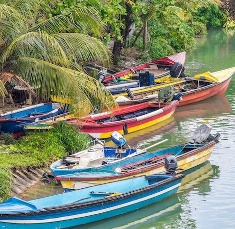Colourful boats docked on river bank.