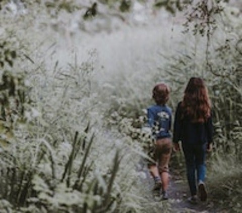 Two children walking in forest