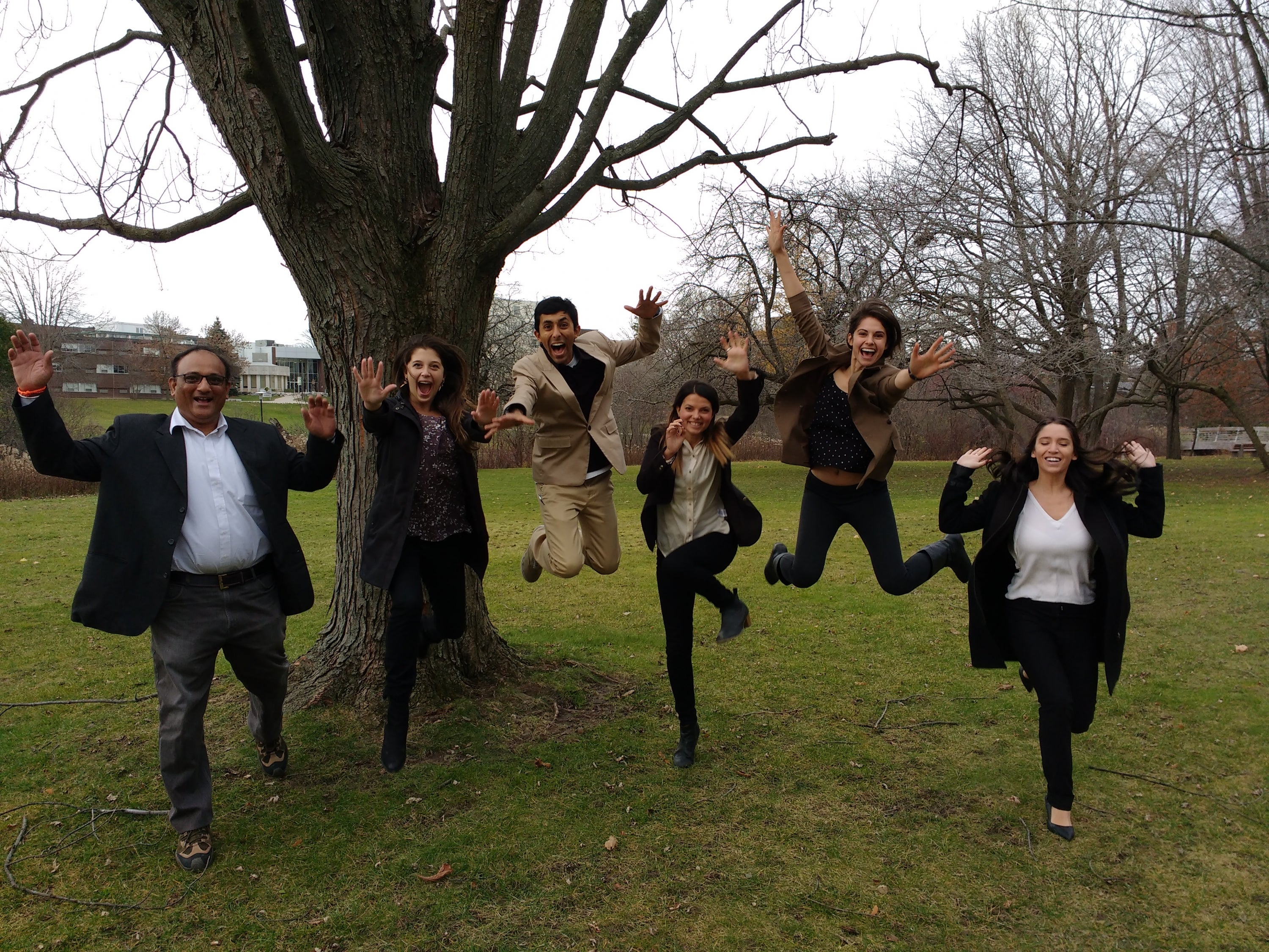 University of Waterloo students leaping in the air outside