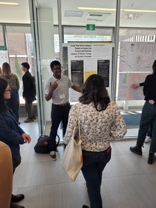 Student presenting poster to conference attendee