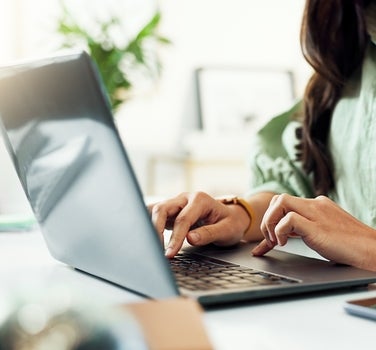 Hands typing at computer