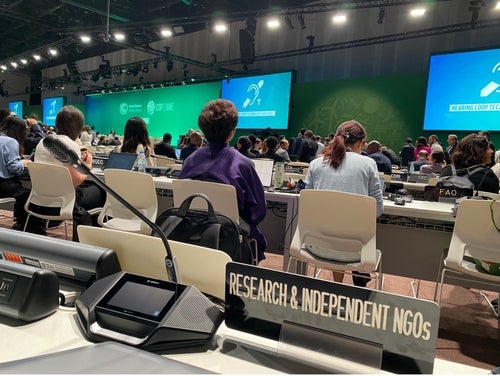 COP 28 plenary room with microphone, desk and large screens