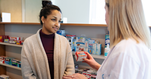A pharmacist talking to a student about a prescription drug