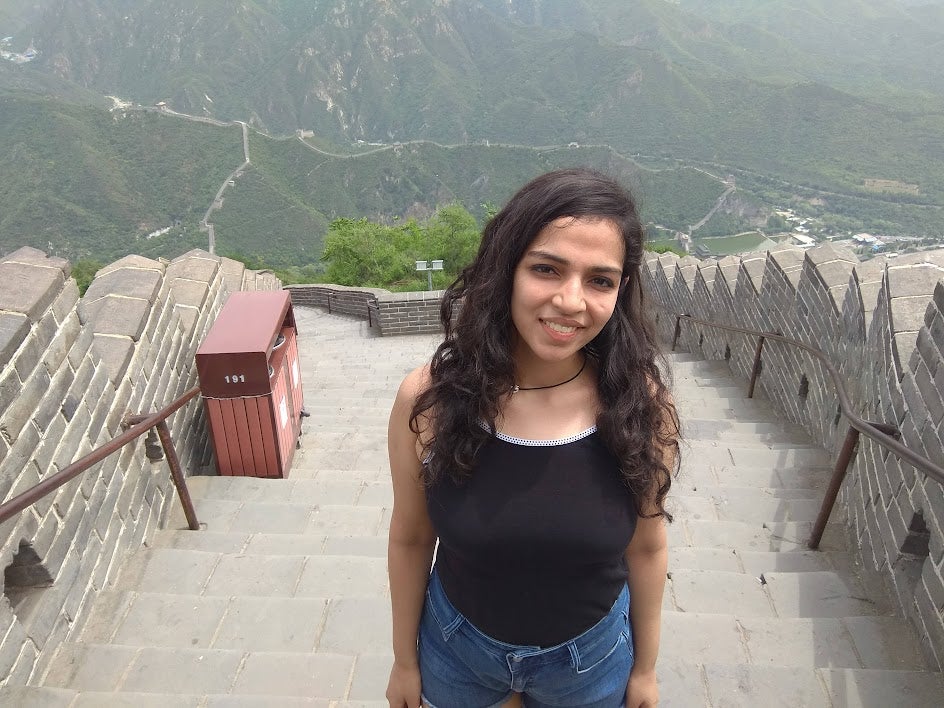 A photo of Vrushti standing on the Great Wall of China.