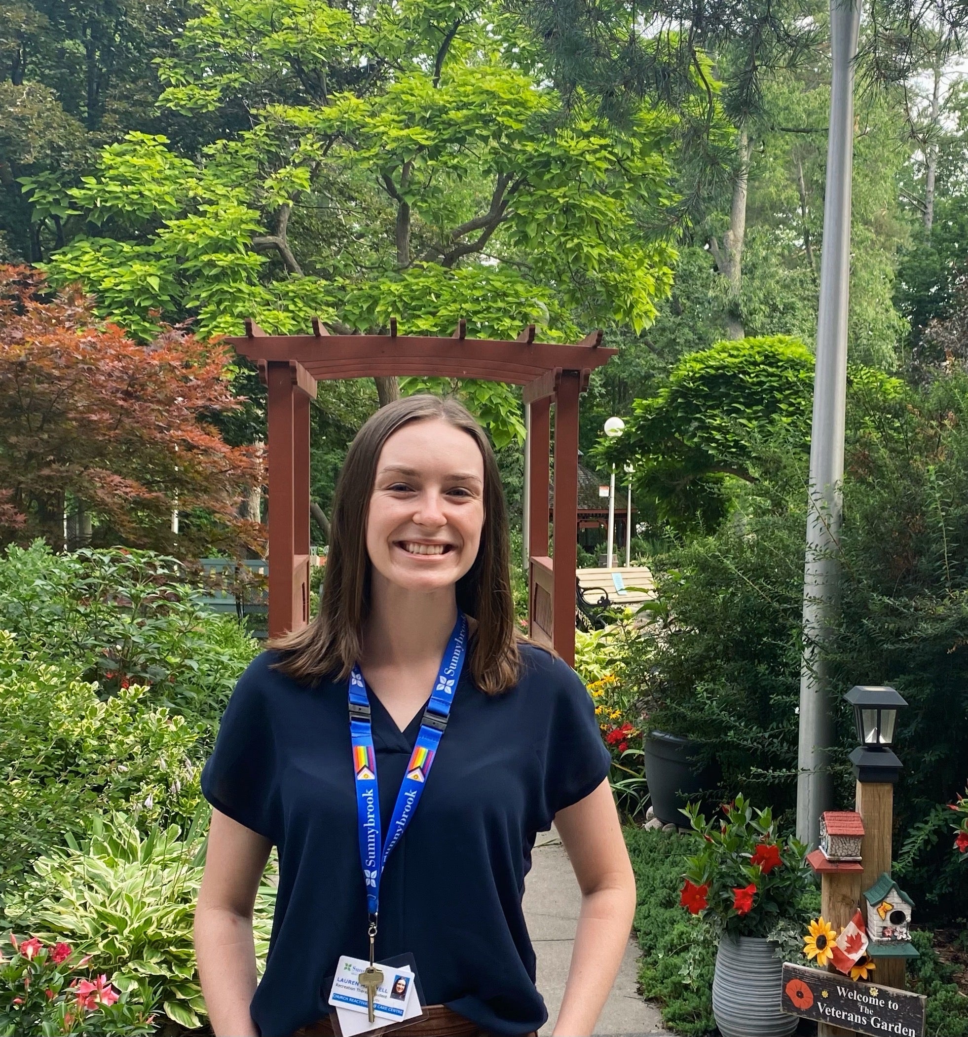 A photo of Lauren standing in a garden at the veteran's centre.