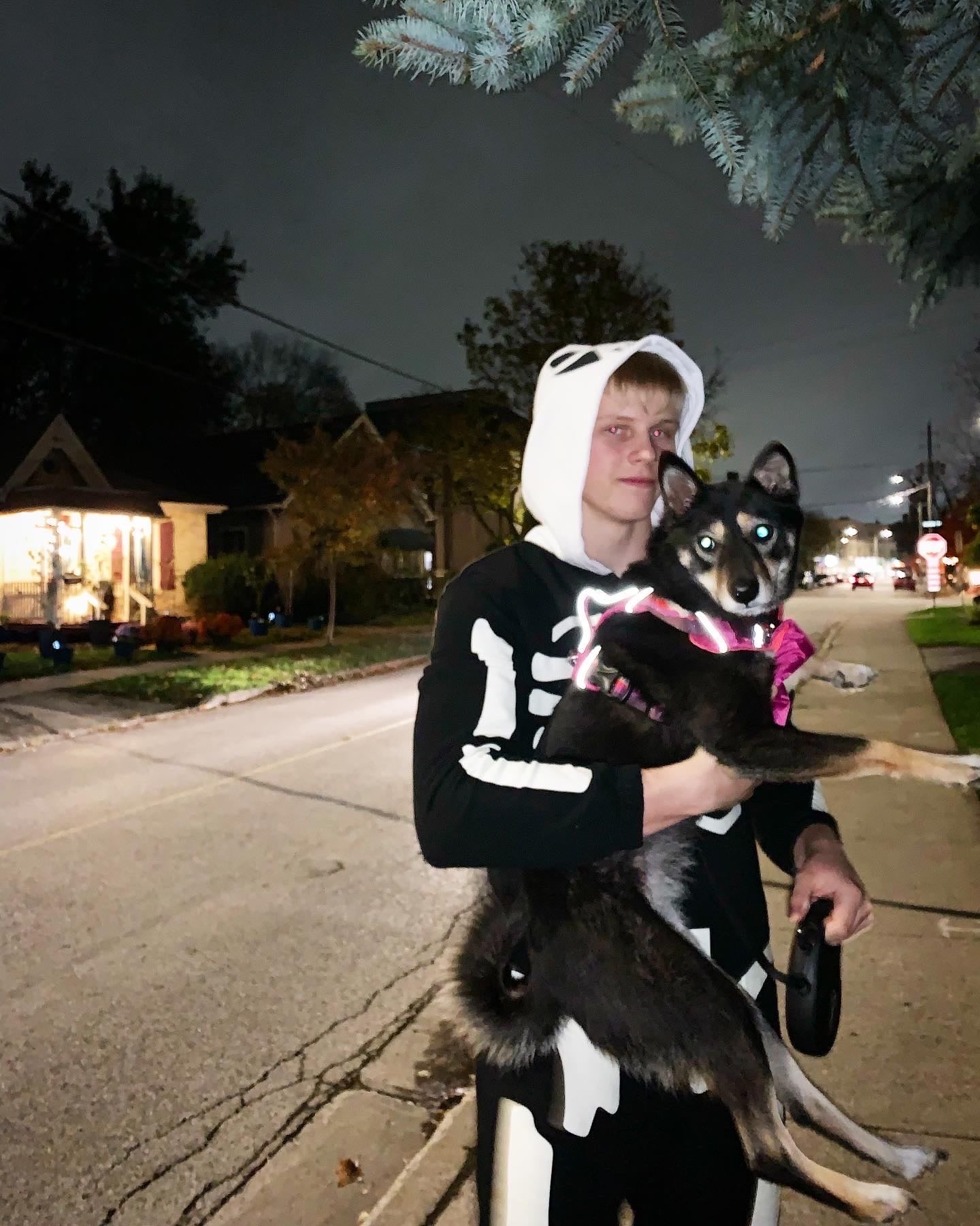 A photo of Max holding a dog.