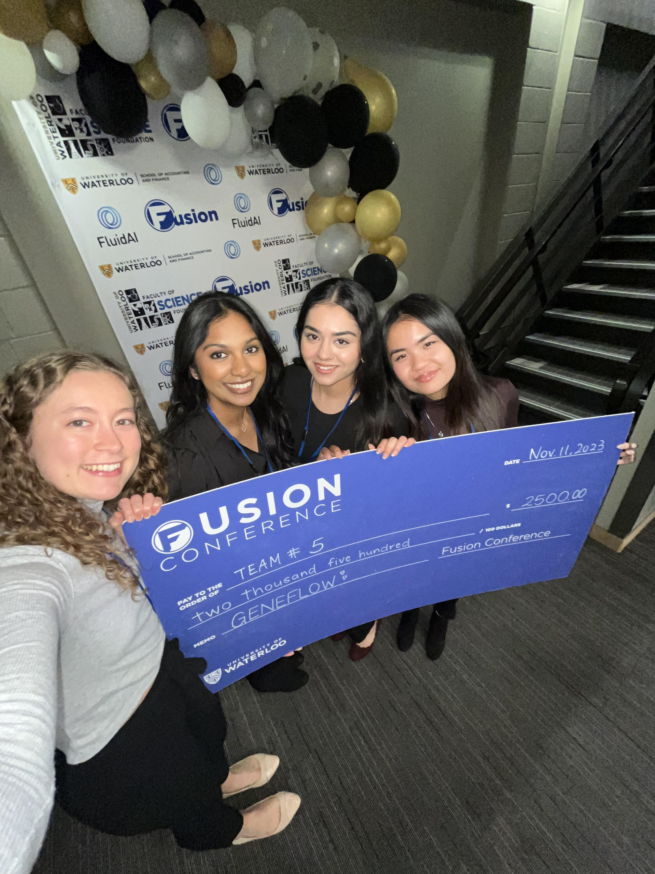Sophia and her fellow teammates holding a Fusion Conference cheque for 2500 dollars.