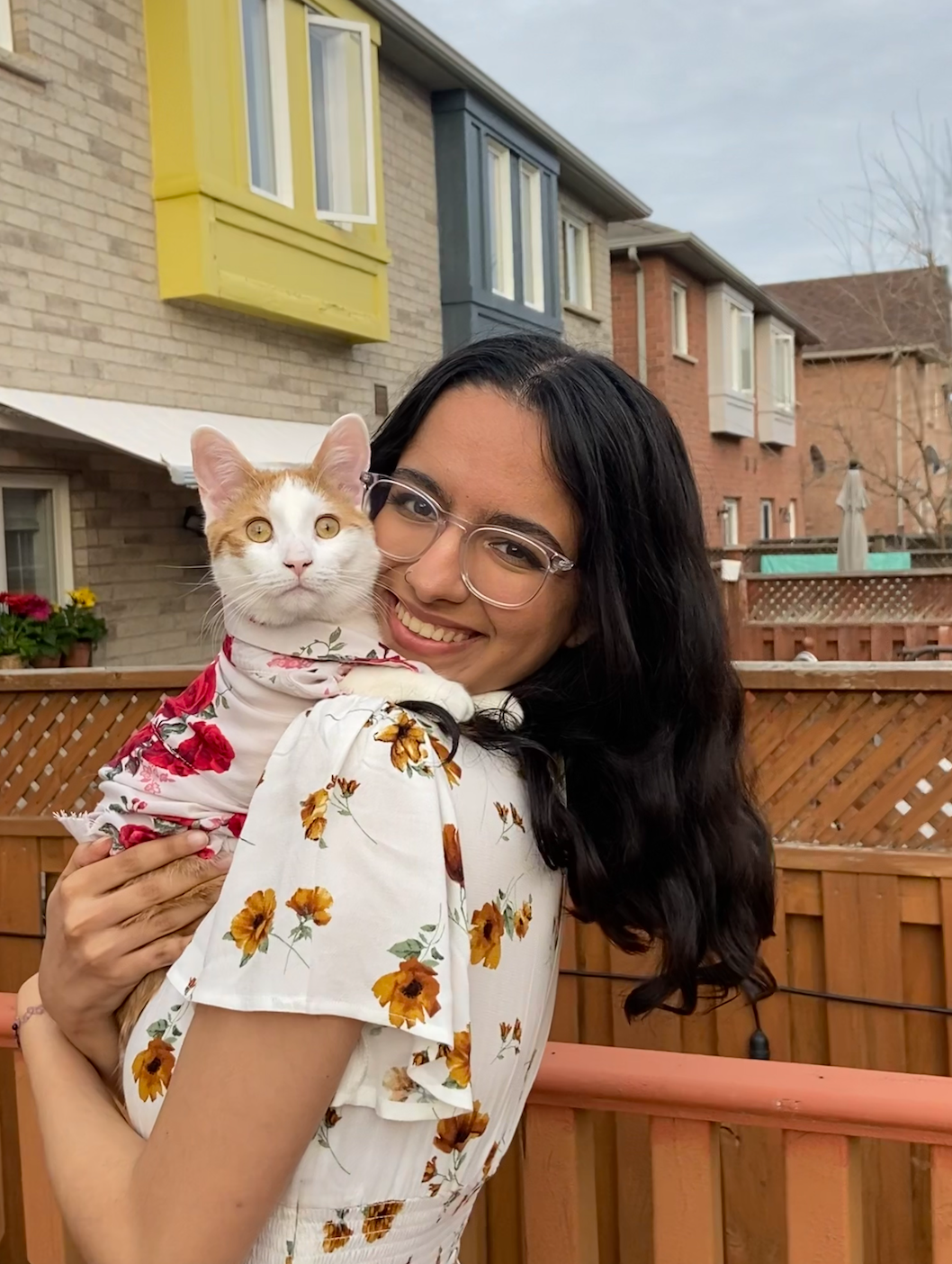 A photo of Ina holding a cat and smiling.