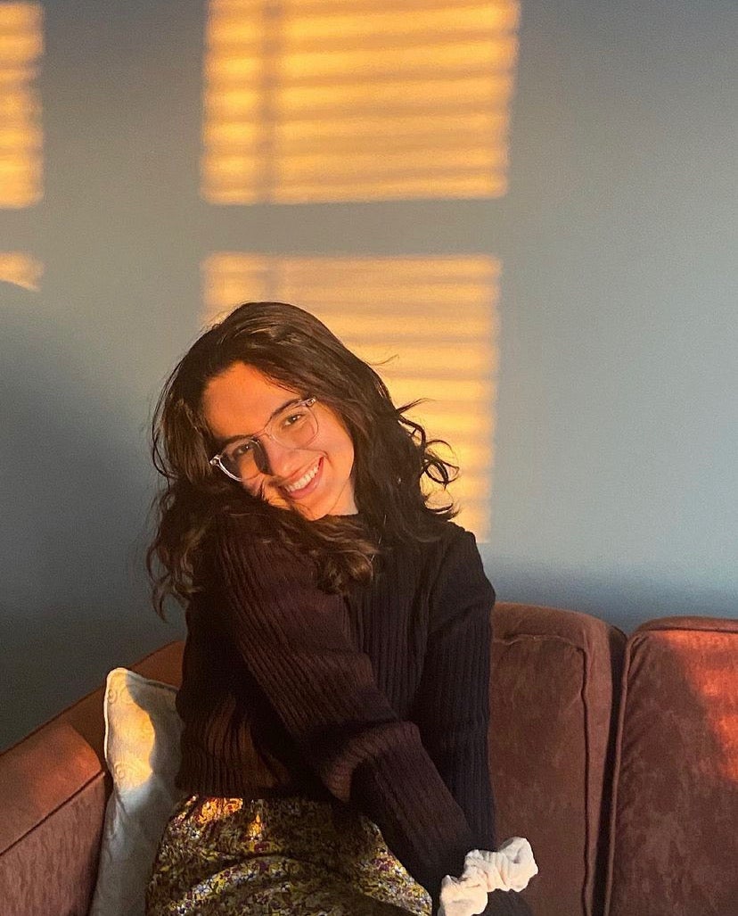 A photo of Ina sitting on a couch and smiling.