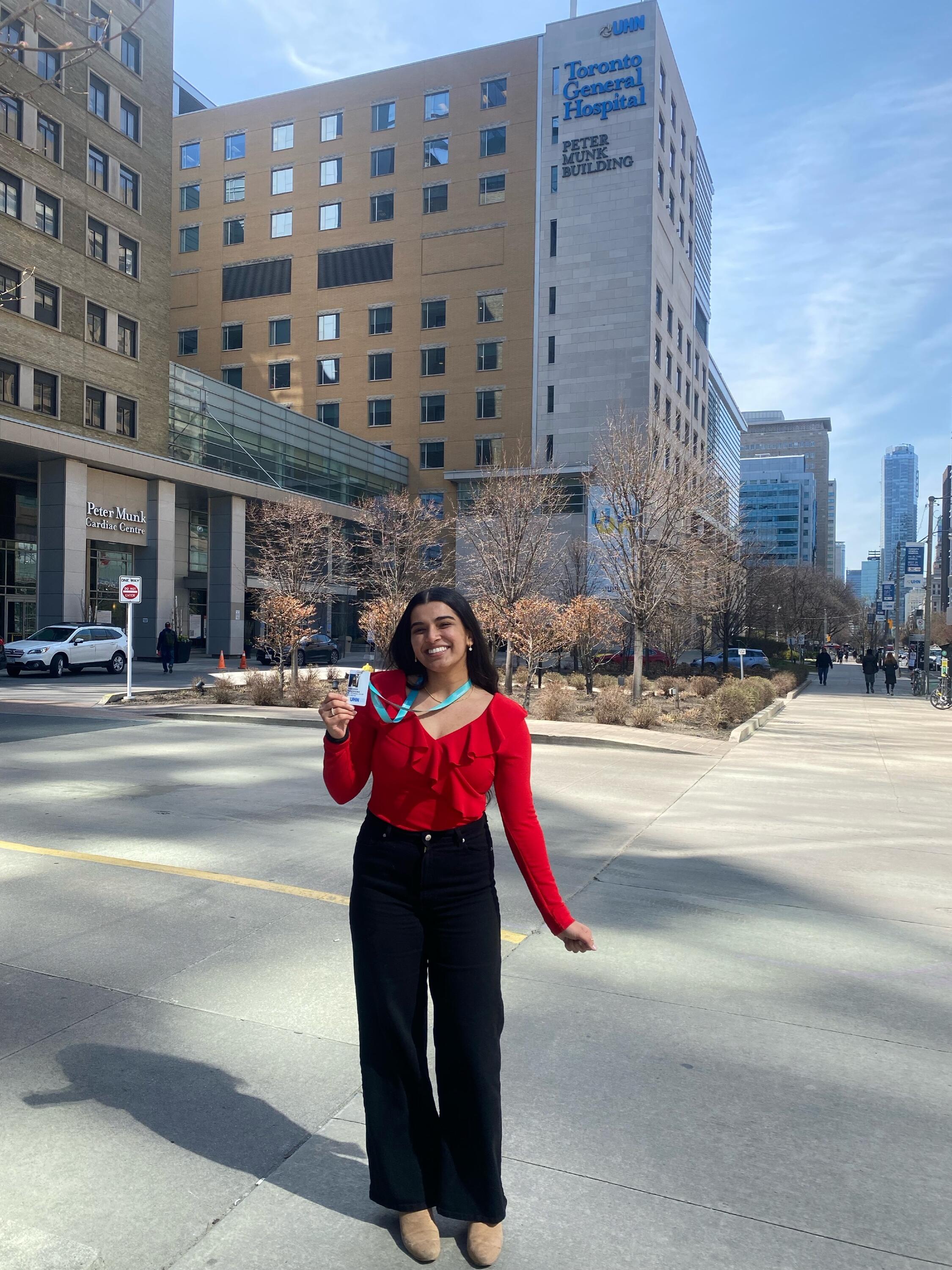 A photo of Tanveer smiling in front of the Toronto General Hospital building.