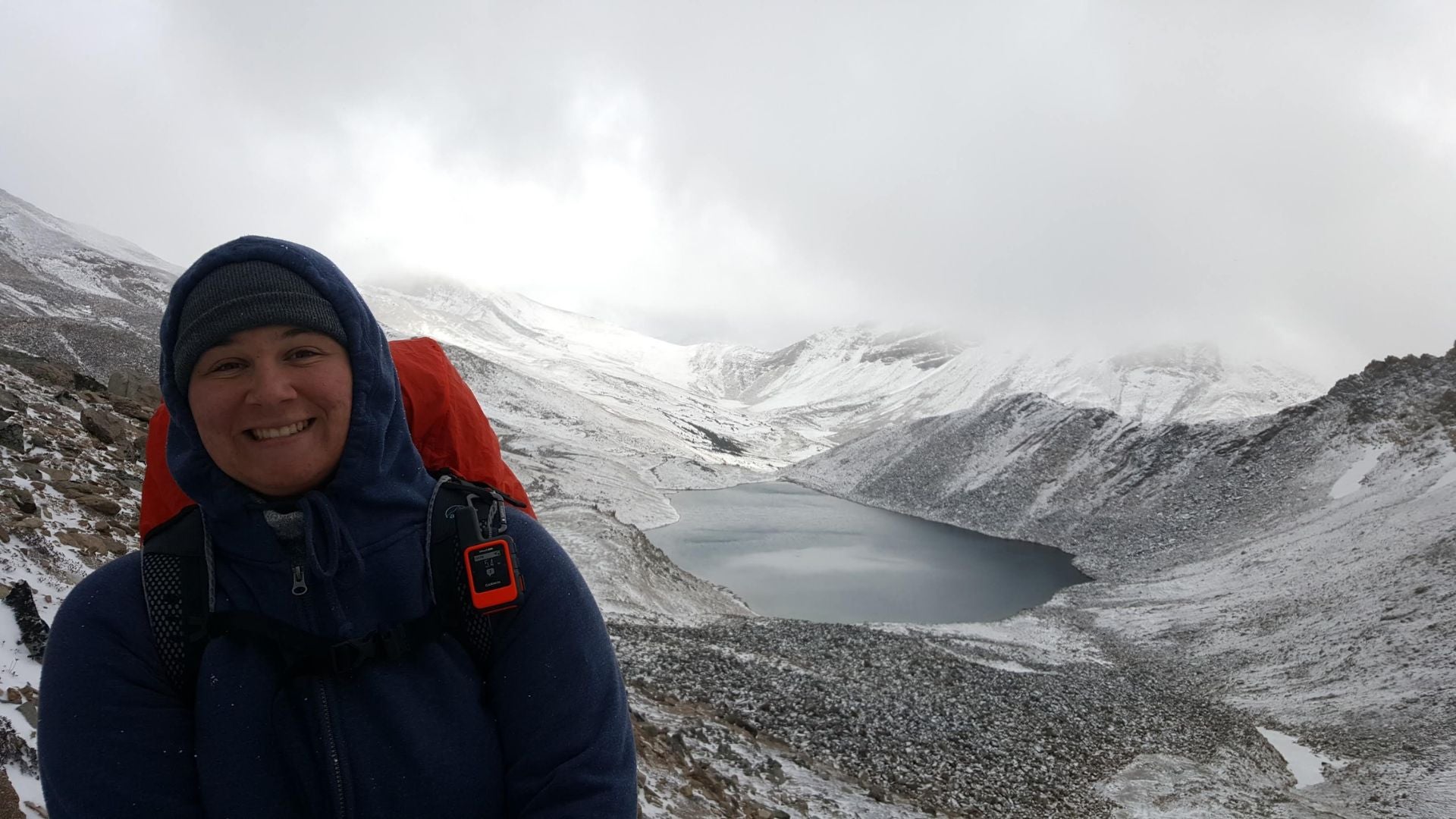 Ashley Ferreira smiling while hiking on a snowy mountain.