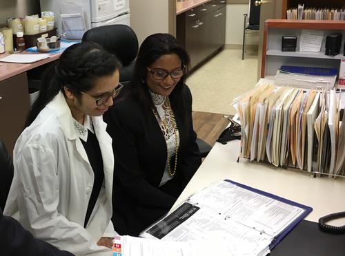 Co-op student Jashandeep Sohal reviews test results at the Waterloo Walk-in Clinic with owners Rex and Meera Mohamed.