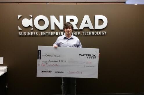 Andrew Leest holding his check after being announced one of the four winners in the E Co-op pitch competition.