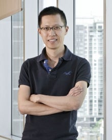 Ivan Yuen, in front of office buildings