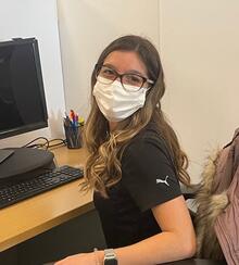 Vanessa Vanpopic wearing a mask sitting at her desk at Toyota