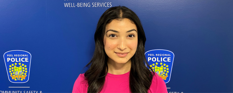 Maham Surahyo standing in front of a Peel Regional Police backdrop 