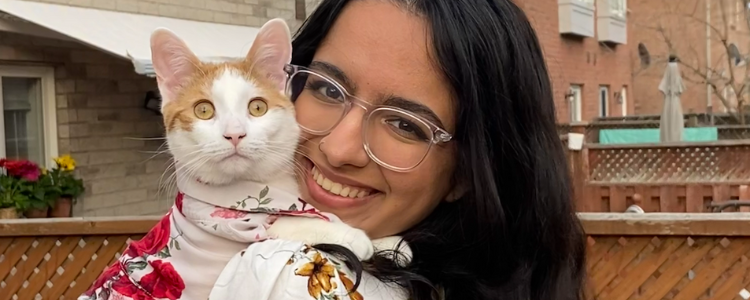 A photo of Ina, a UWaterloo Arts co-op student, holding a cat and smiling.