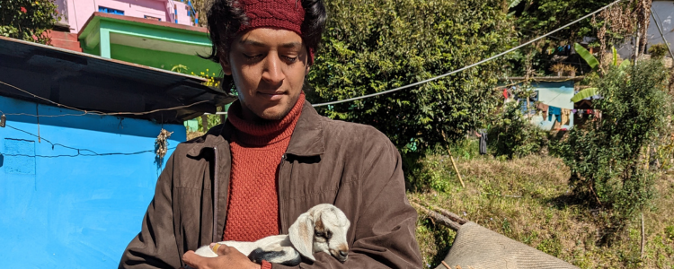 University of Waterloo student, Aryaman Chaturani, holding a baby goat.