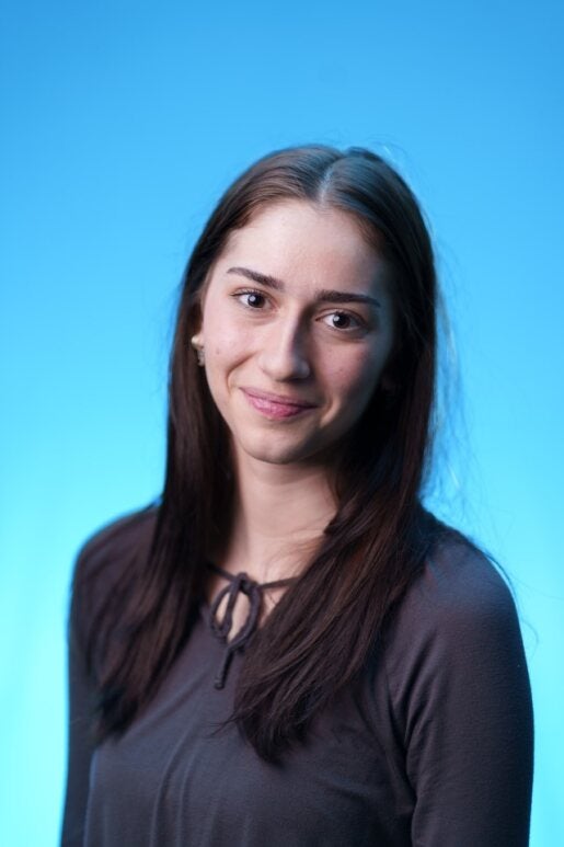Milena Gojsevic smiling in front of a blue background