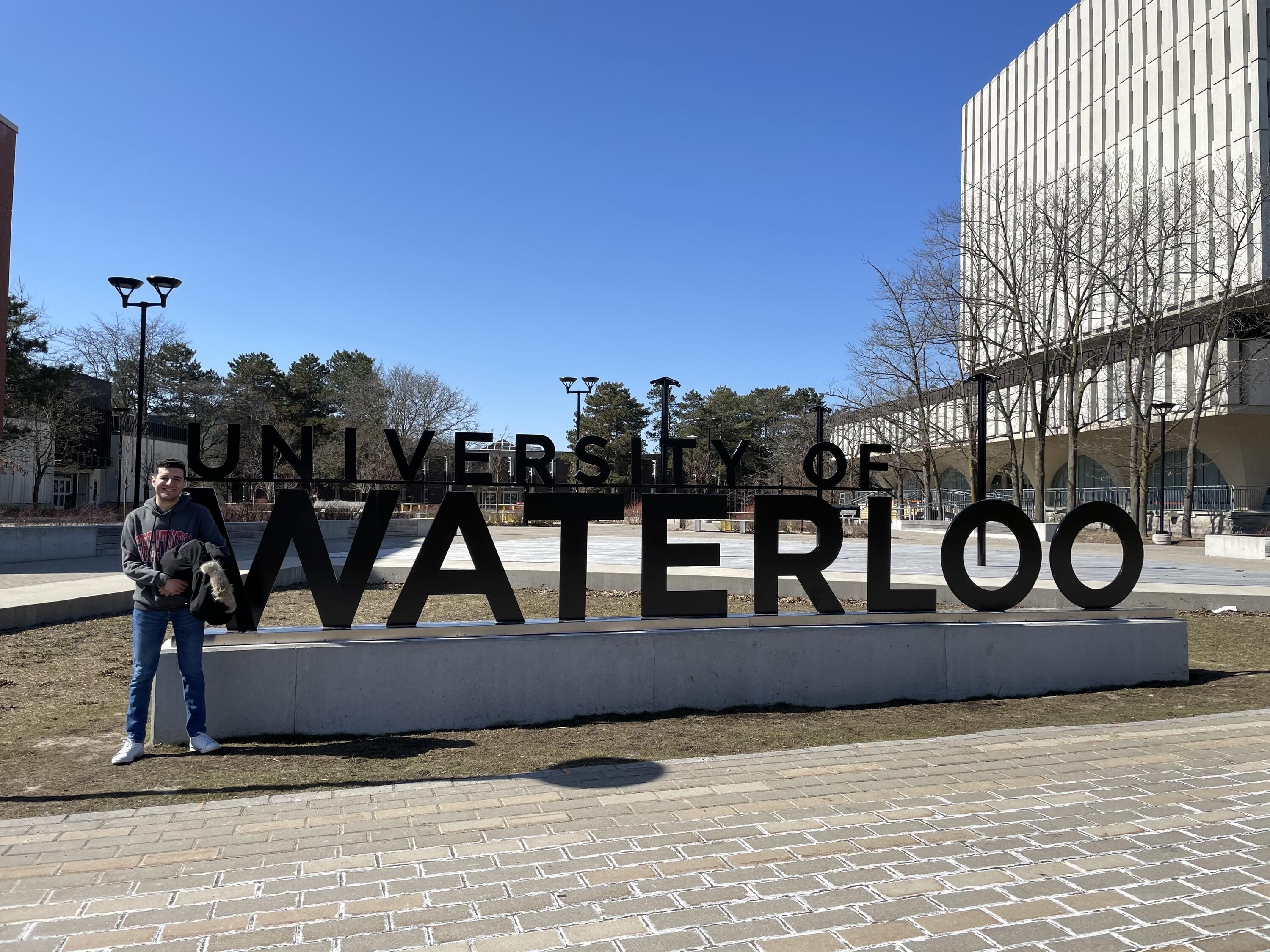 Souhail posing next to the University of Waterloo sign 