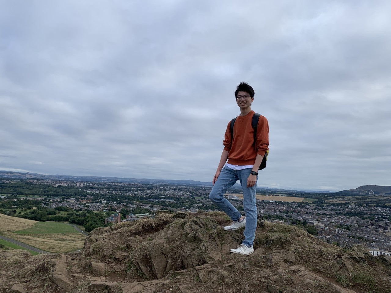 Alex standing at the top of a mountain 