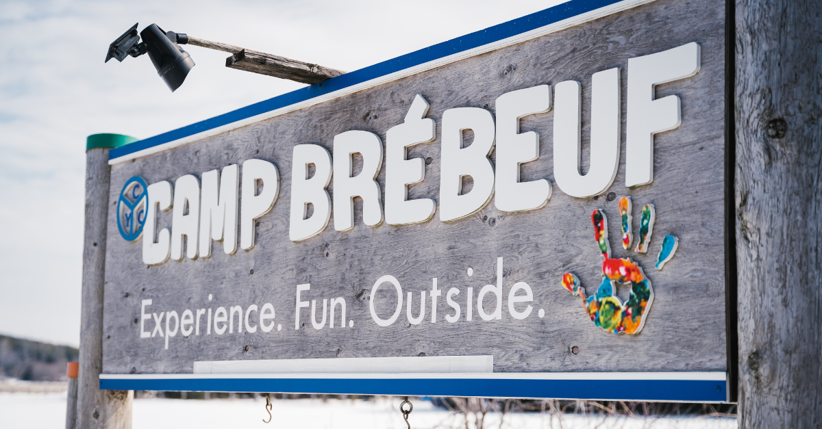 Wooden sign inscribed with the words 'Camp Brebeuf - Experience.Fun.Outside