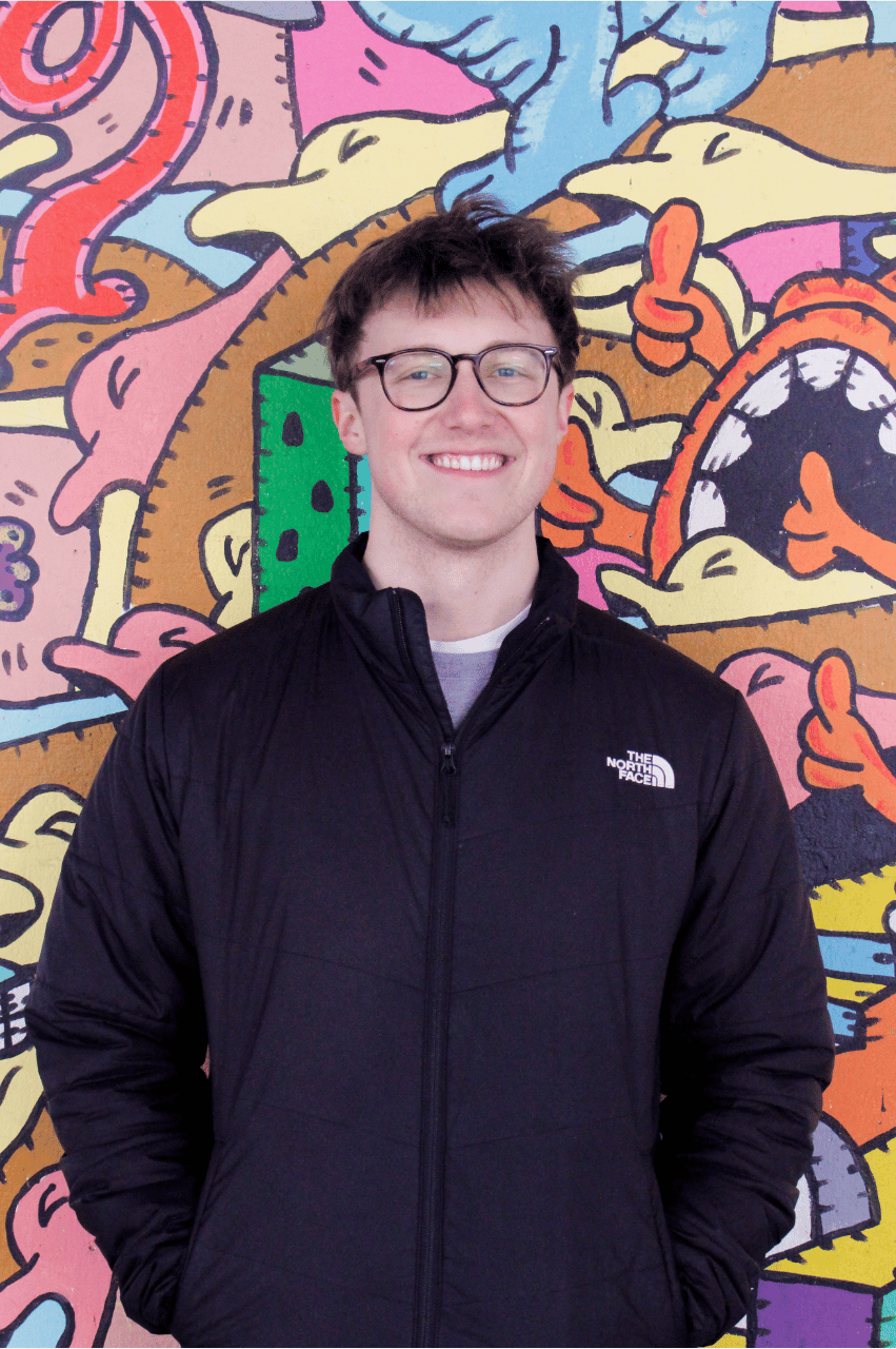 Eric smiling against a colourful background
