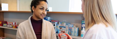 A pharmacist talking to a student about a prescription drug