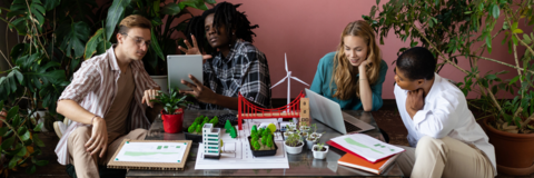 A group of diverse university student change makers discussing environmental problems at a table 