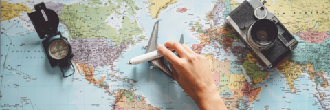 Top view of young woman planning a vacation using a world map