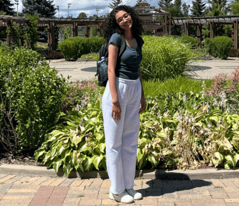 Carole Hanna posing in front of a garden