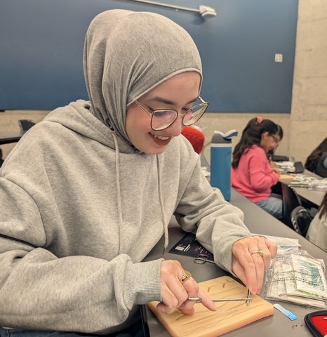 Ameera Khan cutting a wire in a classroom